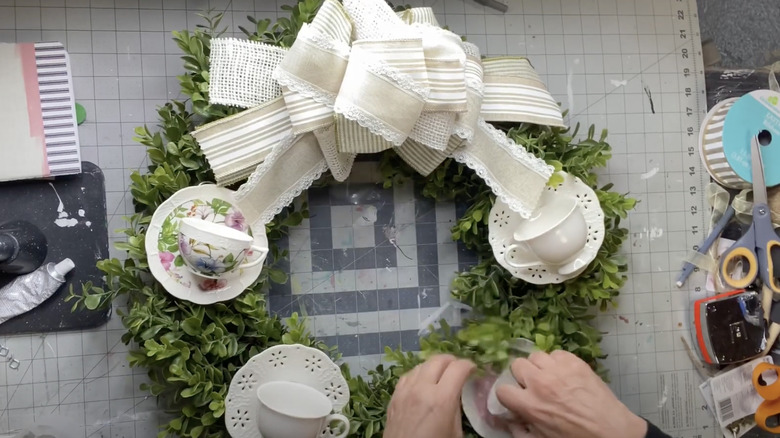 Teacups and saucers on a green wreath