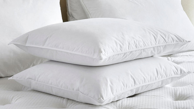 White pillows sitting stacked on a bed