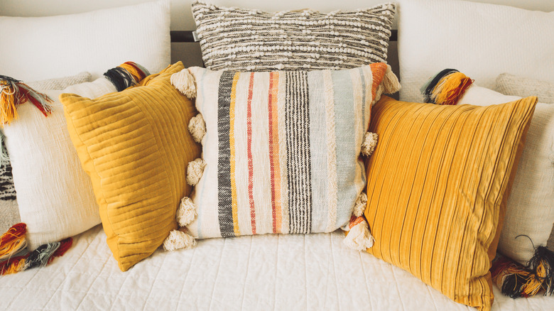 Decorative striped throw pillows sitting on a bed.