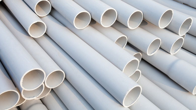 A pile of white PVC pipes stacked on top of each other