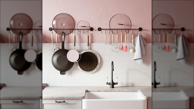 A set of kitchen wall racks against pink wallls with white backsplash in kitchen