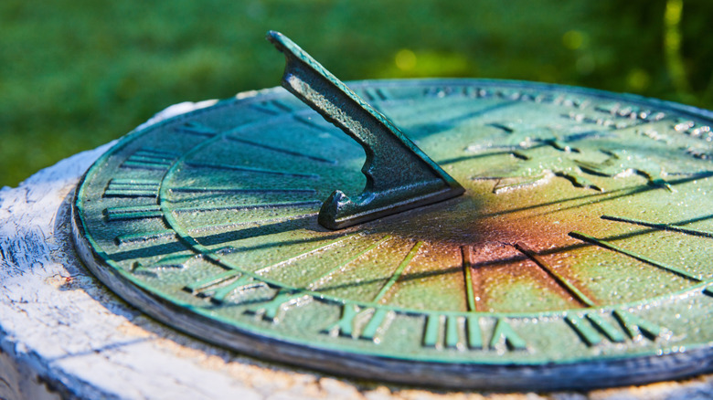 Metal sundial with blue-green patina in garden