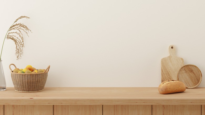 Blond wood counter with a basket of lemons and cutting boards