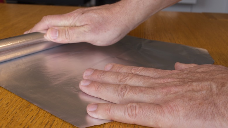 person rolling out foil