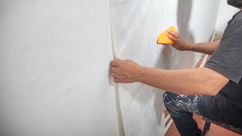 person applying wallpaper