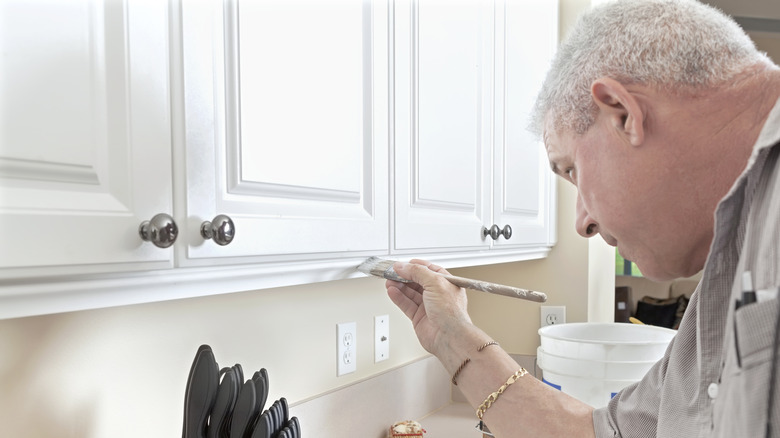 Man painting kitchen cabinets