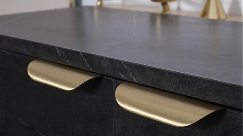 Stone counter and cabinet doors with gold edge pulls
