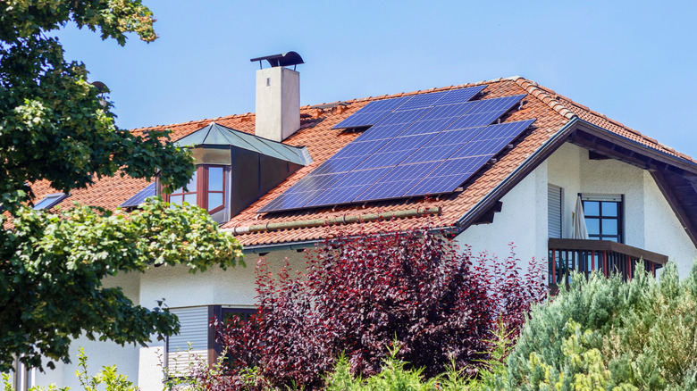 Beautiful home with solar panes on clay tile roof