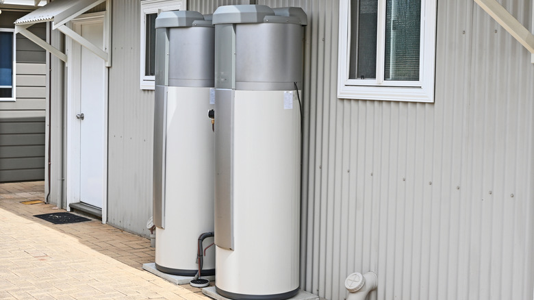 Two large water heaters attached to an outside wall