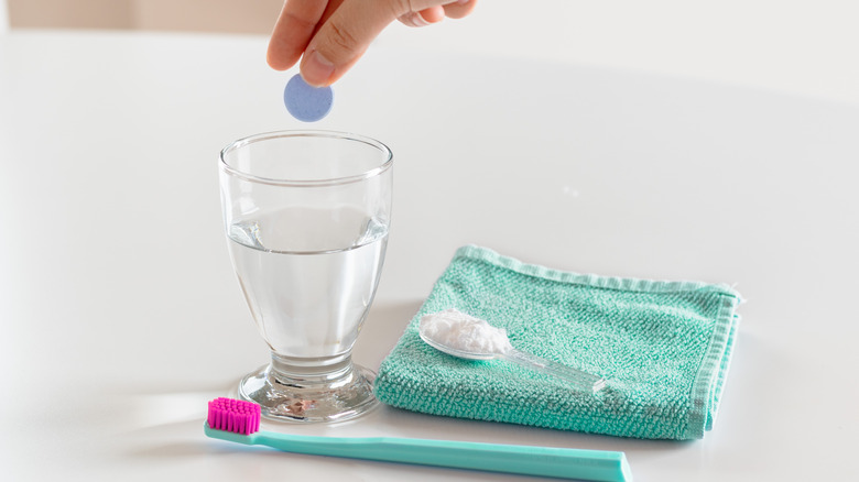 dropping denture tablet in water