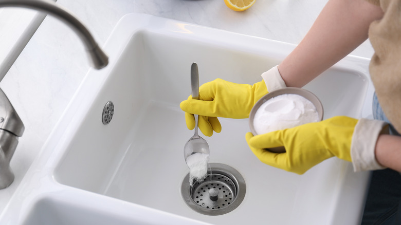 Woman pouring powder down drain