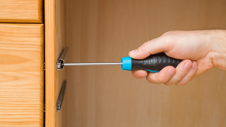 man manually screwing drawer