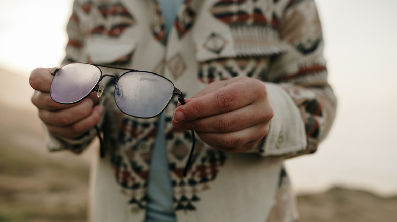 person holding foggy glasses