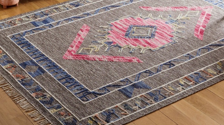 Gray Santa Fe rug with red accents on hardwood floor