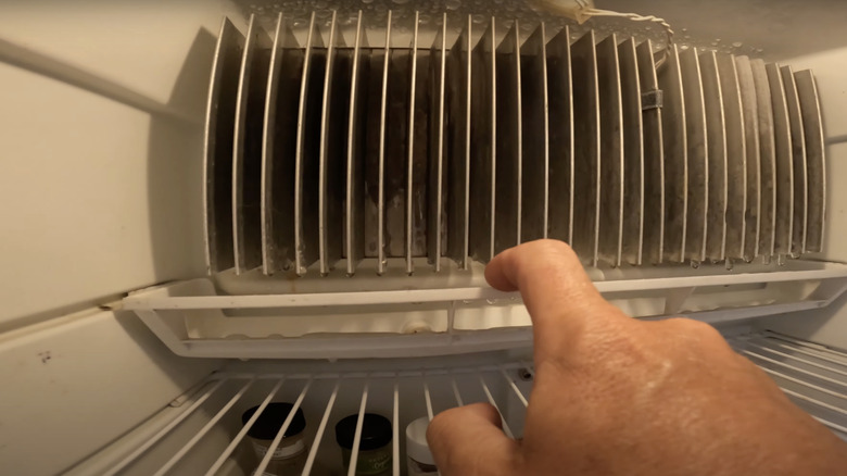 man removing refrigerator drip pan