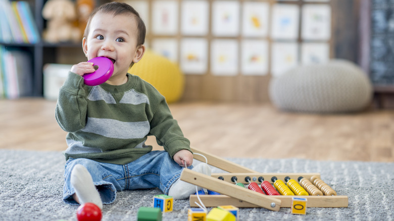 baby boy gnawing on toys