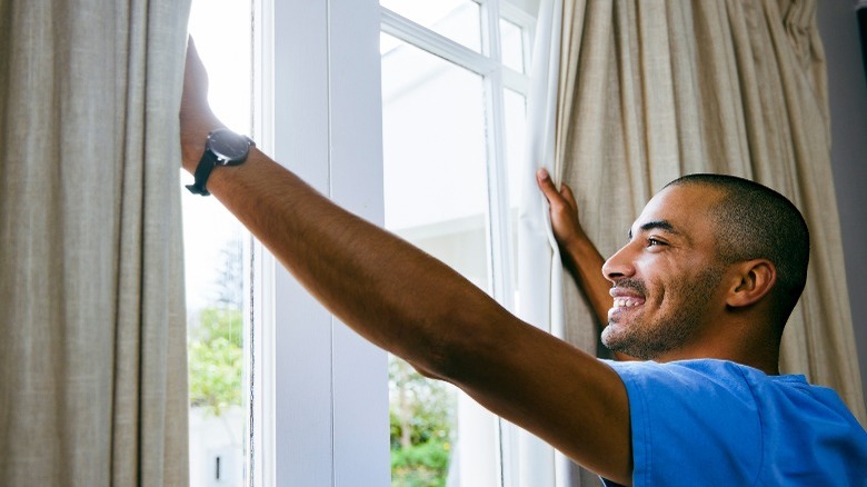 Happy man opening window