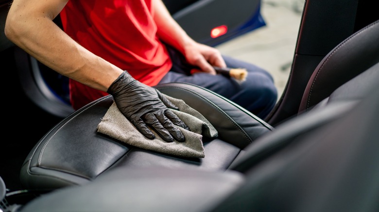 Person detailing a car seat