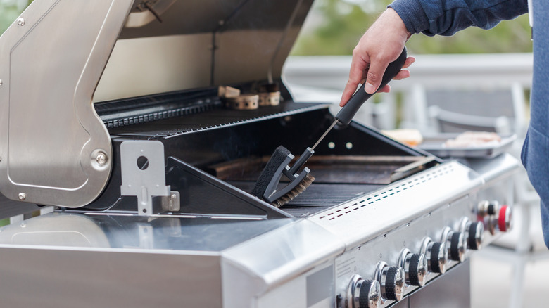 Person cleaning a barbecue grill