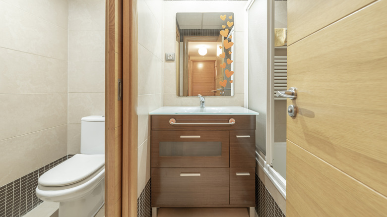 Bathroom with a toilet closet that is separated from the main area by a pocket door