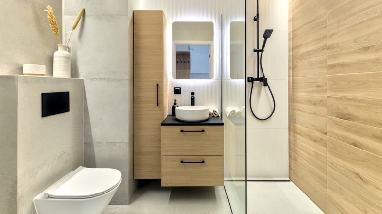 Japandi style bathroom with wood cabinets and wood and concrete wall materials