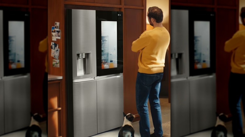 Man and dog looking at LG refrigerator