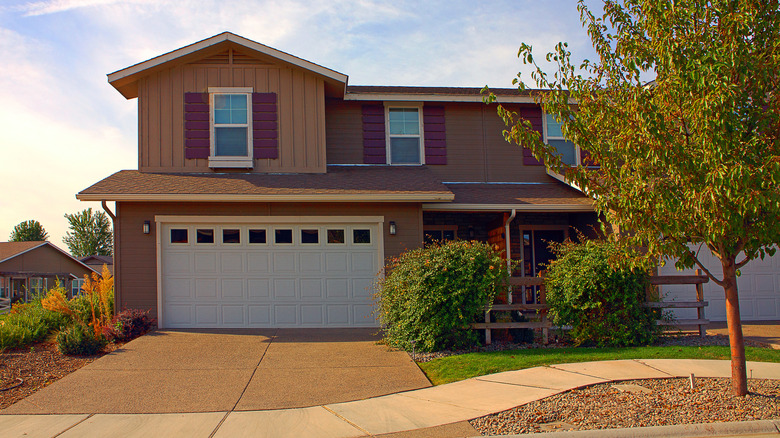 A house with maroon shutters and a white garage door