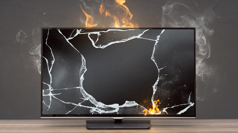 A broken television screen with fire coming out of it