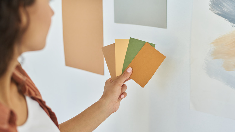 woman holding earthy paint swatches