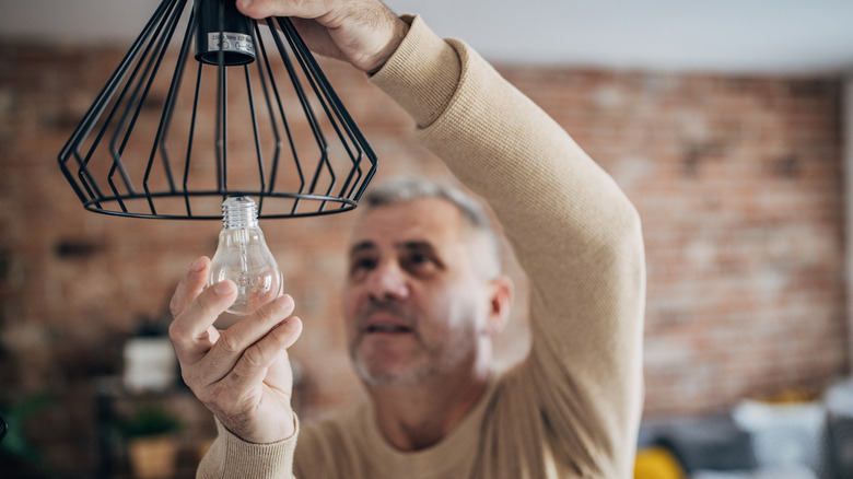 man changing light bulb