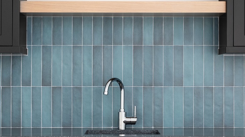 counter and faucet with vertical blue subway tiles