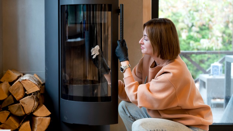 Woman cleans fireplace