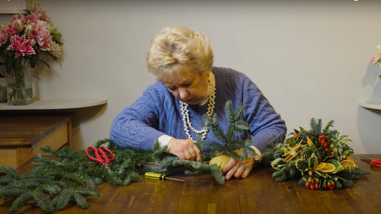 Woman using potato to arrange flowers