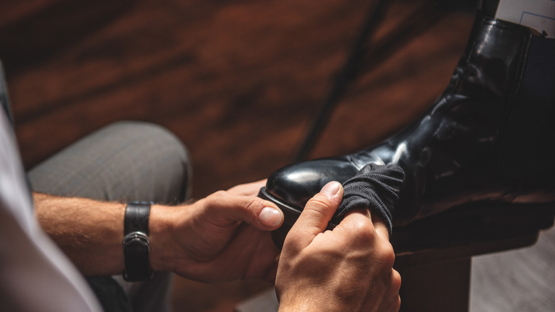 Man cleans leather boot