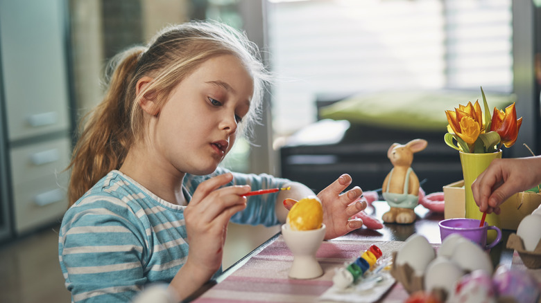 Girl dyeing Easter eggs