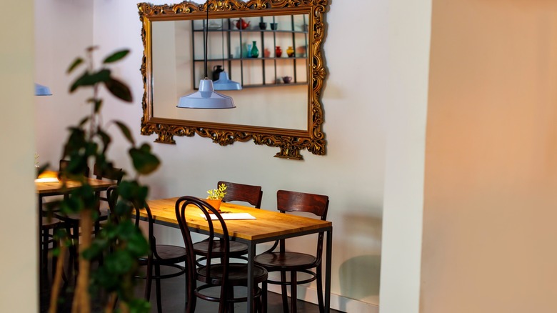 Ornate gold mirror hanging on wall in dining room