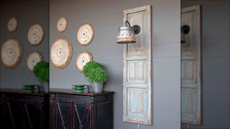 Repurposed shutter with metal a light fixture on wall