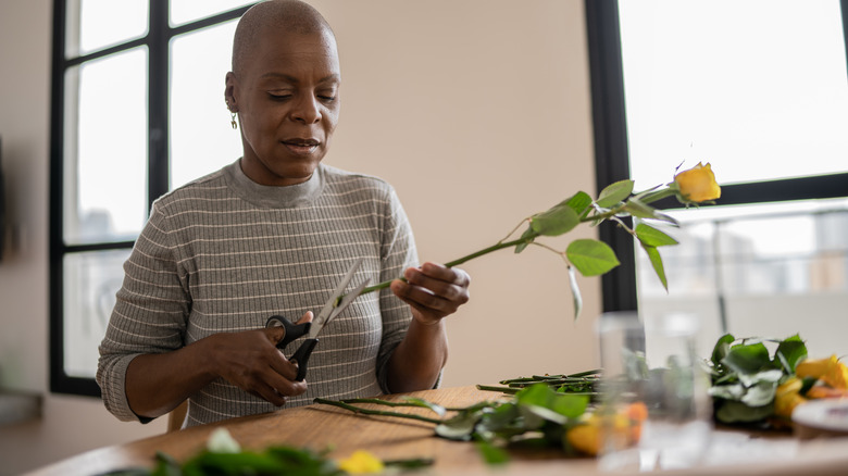 person preparing flowers for vase