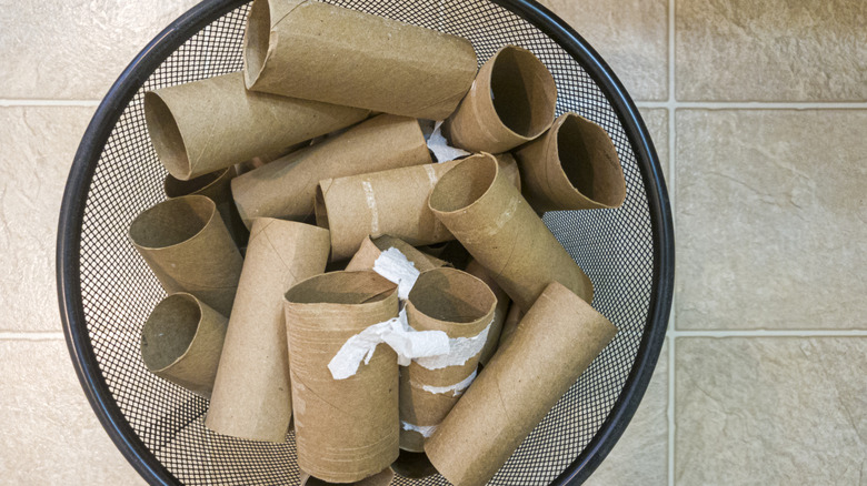 Pile of empty toilet paper rolls in a trash can