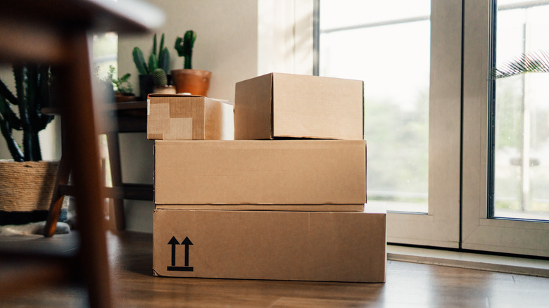 Stack of cardboard boxes on the ground in a house