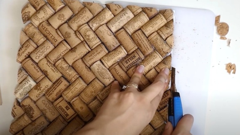 Bird's eye view of person cutting wine cork board with utility knife