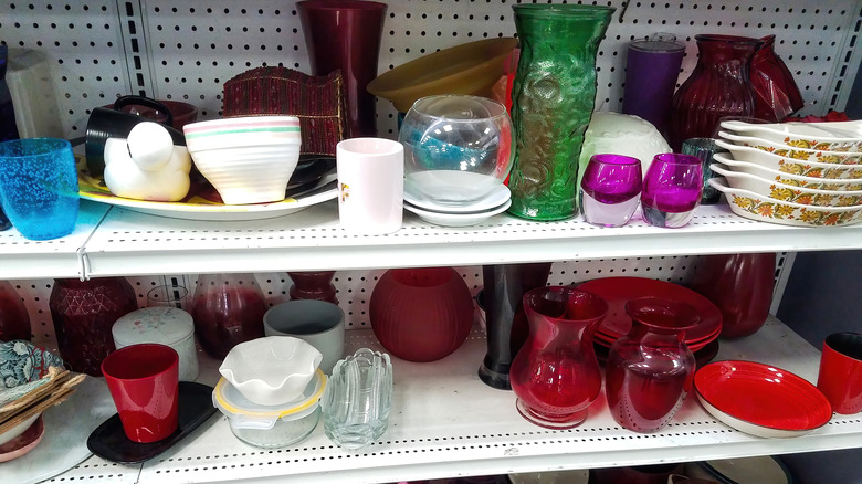 variety of dishes and glassware on thrift store shelves