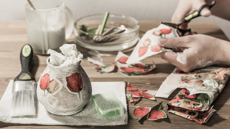 Hands decoupaging a vase