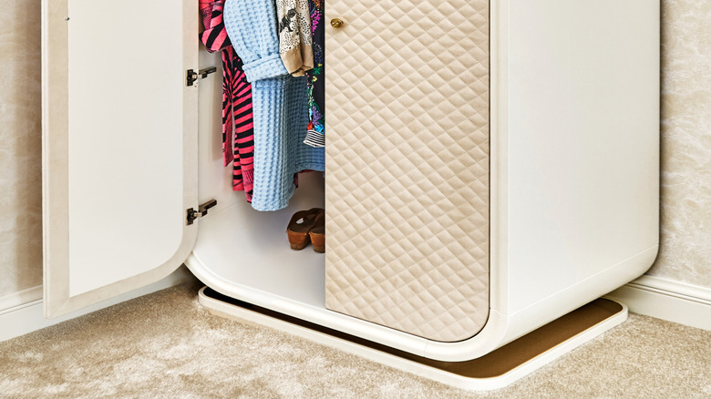 Partially opened white closet with padded doors