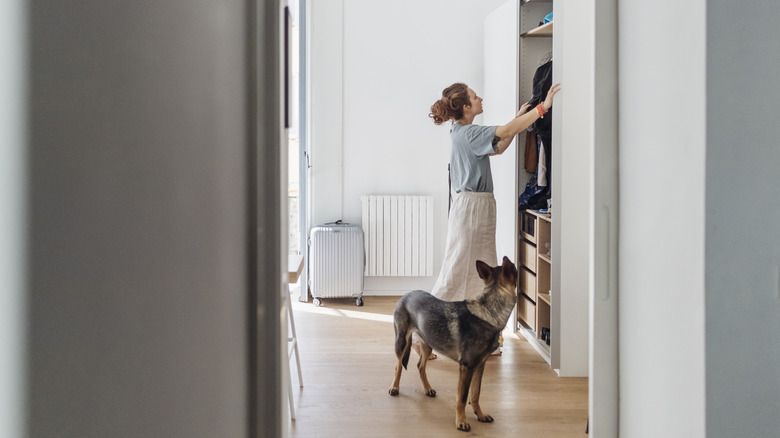 Woman and dog standing in front of an open closet