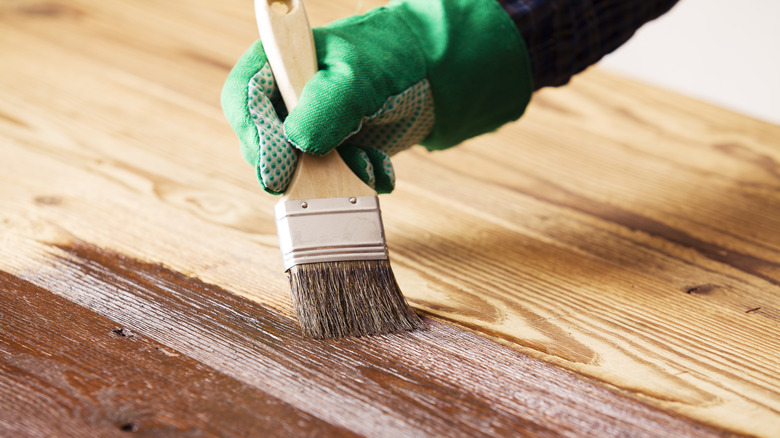 Person painting wood 