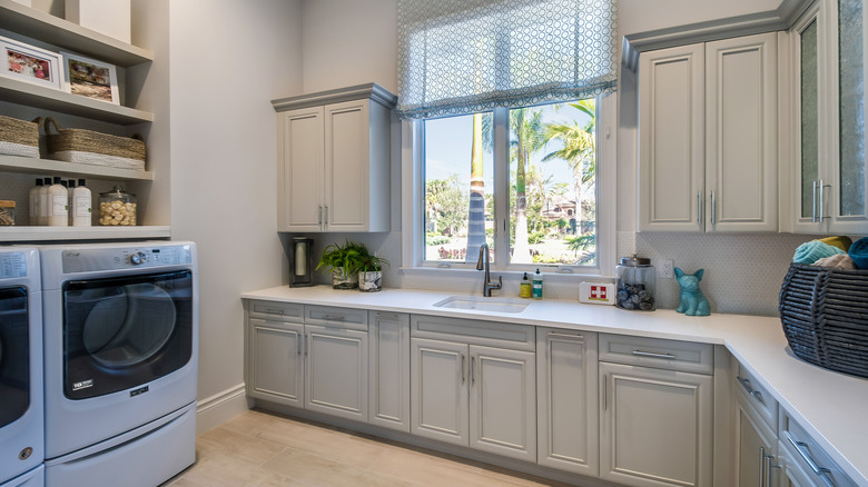 A laundry room with spacious counters and shaker cabinets.