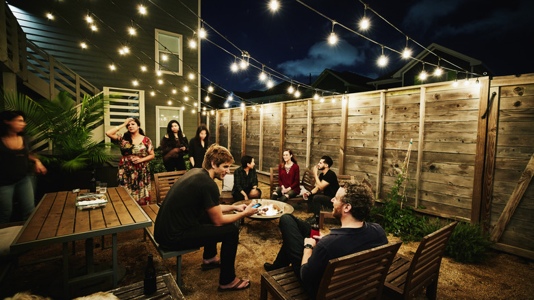 String lights hanging over an outdoor seating area filled with guests