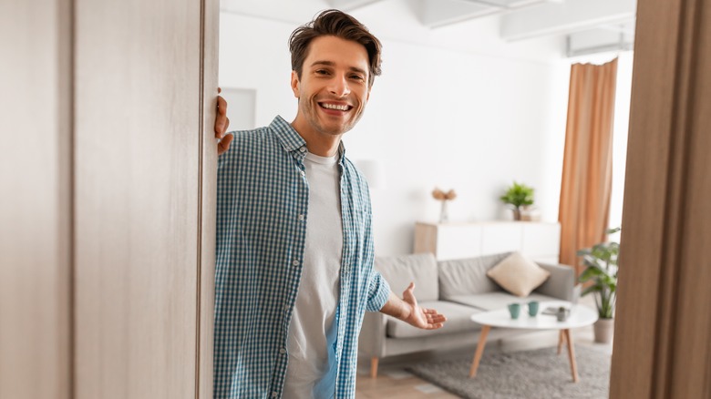 man inviting someone into apartment