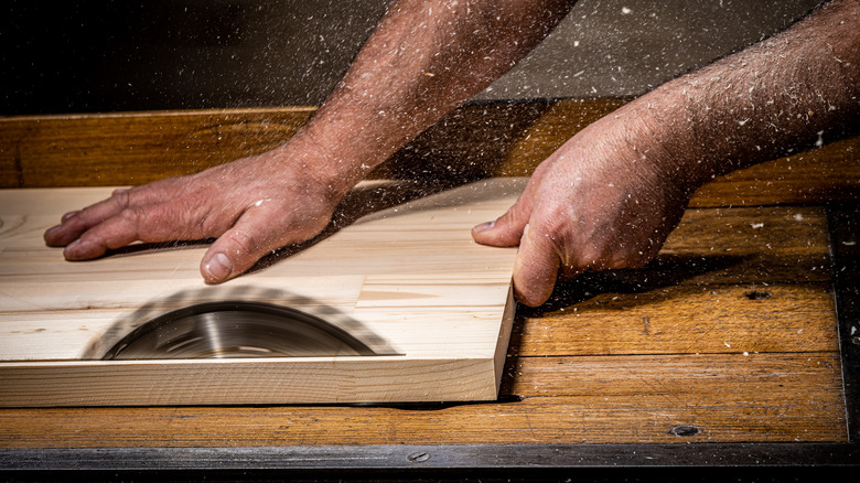 Table saw being used to cut a straight edge on a piece of wood.